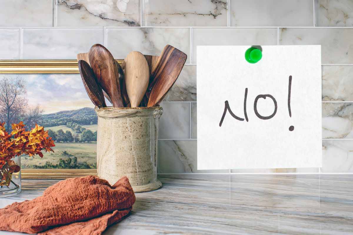 parete piastrellata di una cucina su cui c'è attaccato un post it con scritto no