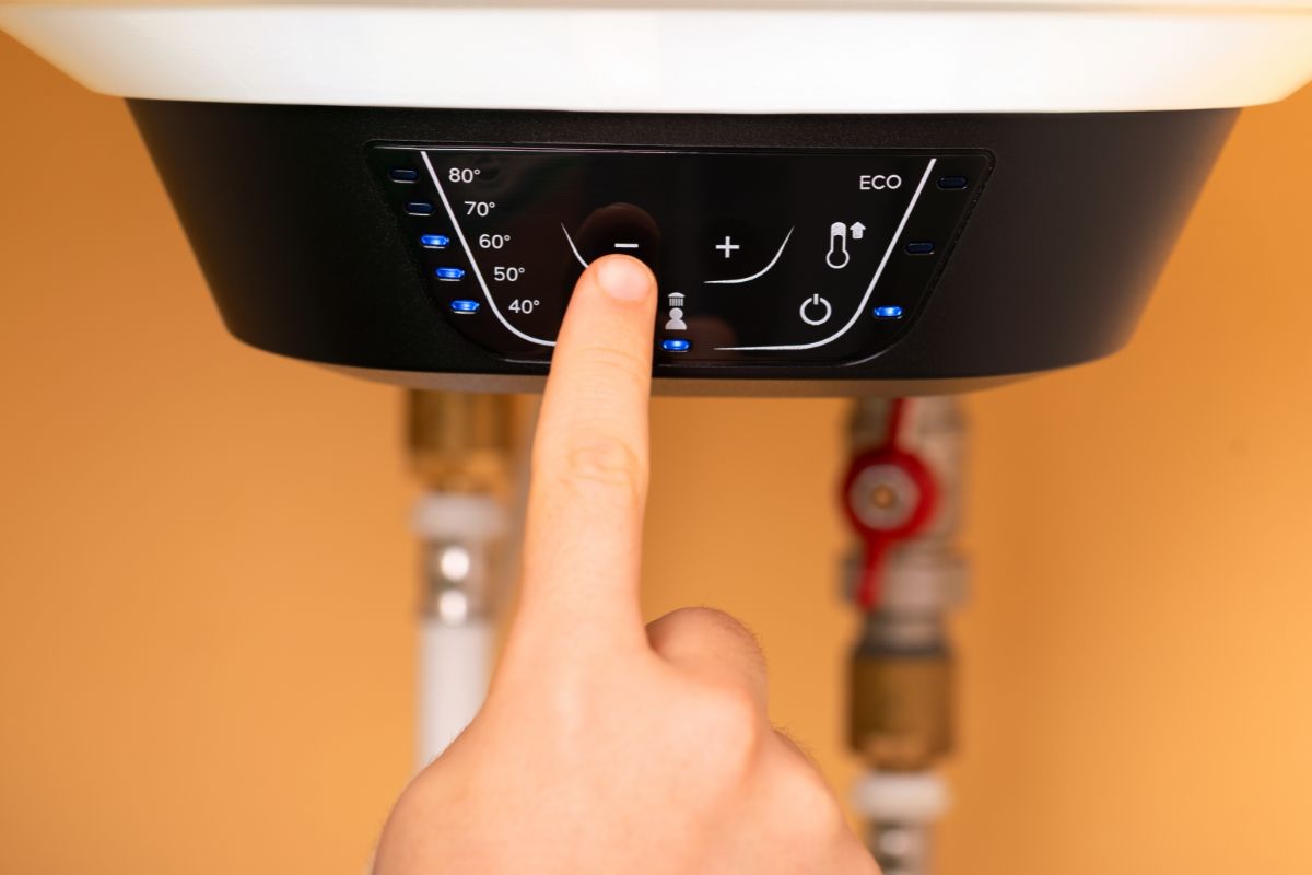 dito che preme pulsante su caldaia