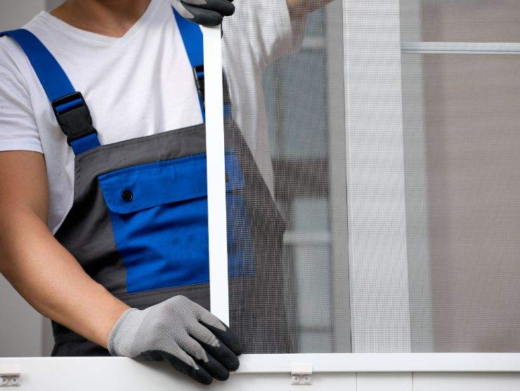 operaio che installa zanzariera