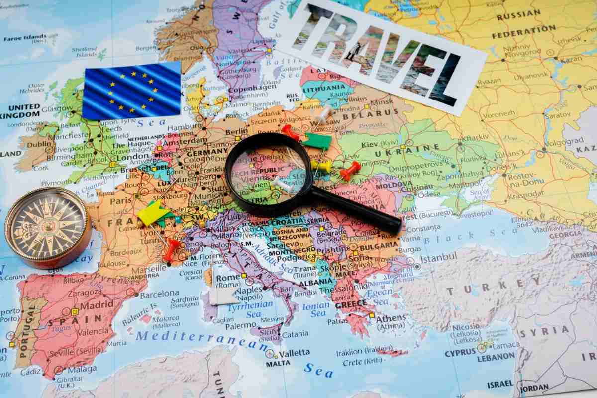 cartina dell'europa con scritta travel e lente d'ingrandimento