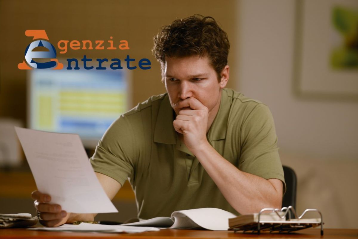 uomo serio con carta in mano e logo agenzia delle entrate
