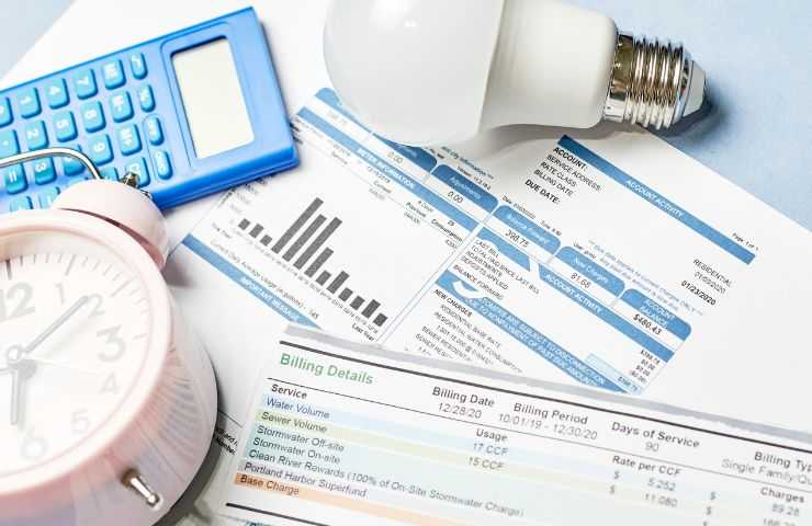 diverse bollette sparse, calcolatrice e lampadina