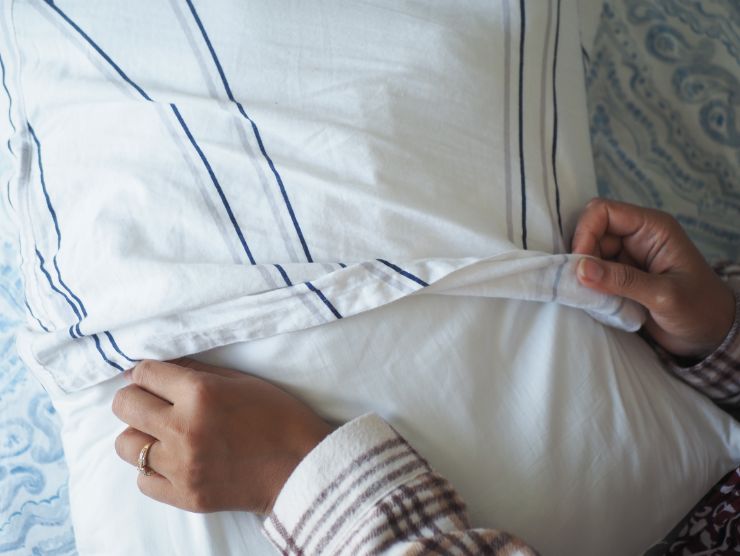 donna che mette federa al cuscino