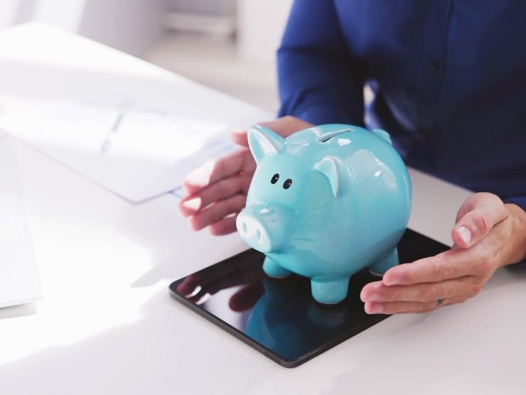 mani che mantengono salvadanaio azzurro