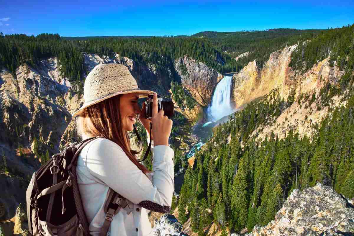 turista che fotografa una cascata