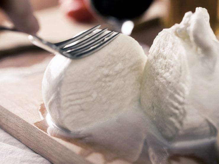forchetta che preme su una mozzarella di bufala